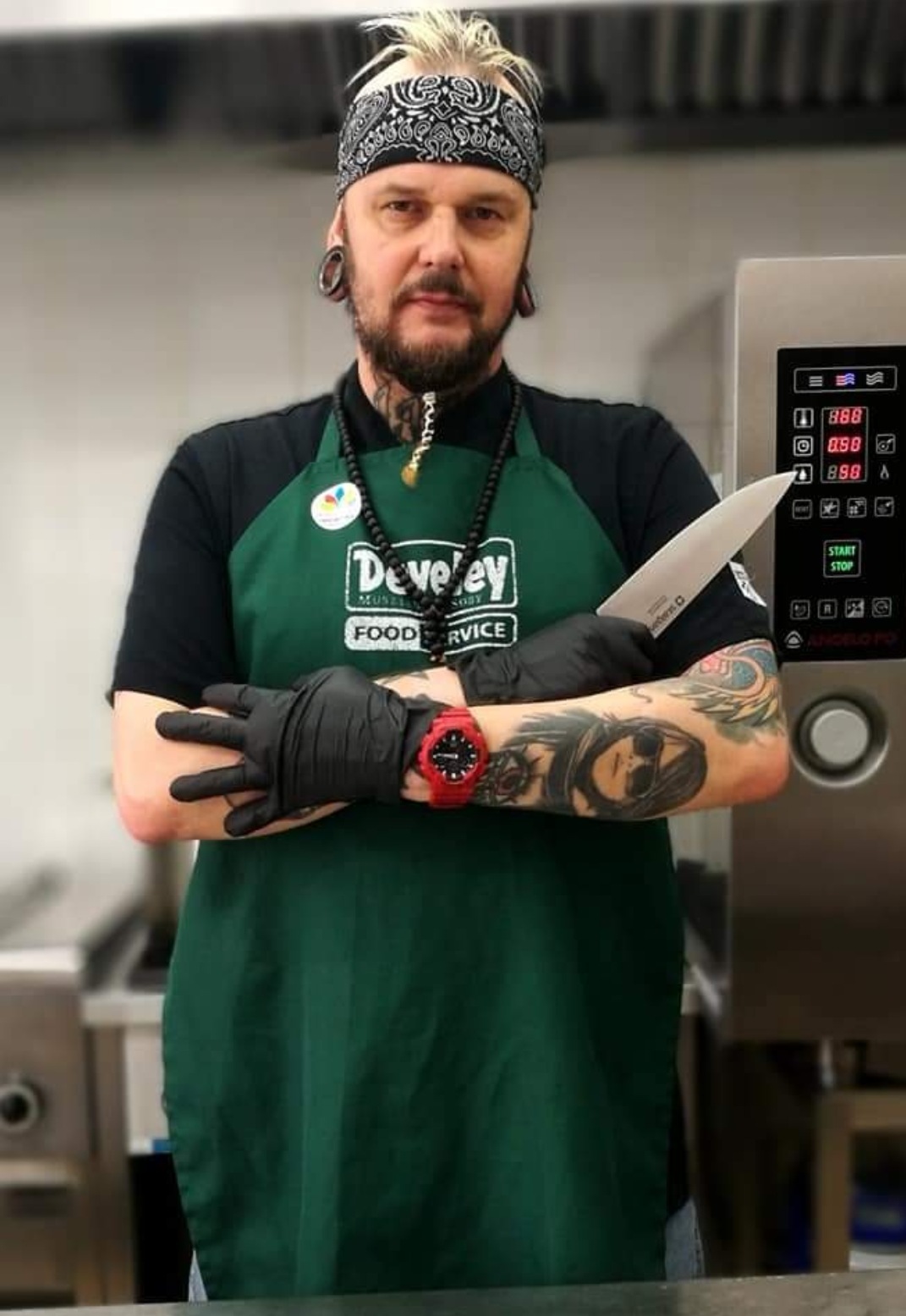 Sebastian Bachanek z nożami kuchennymi, w swojej kuchni